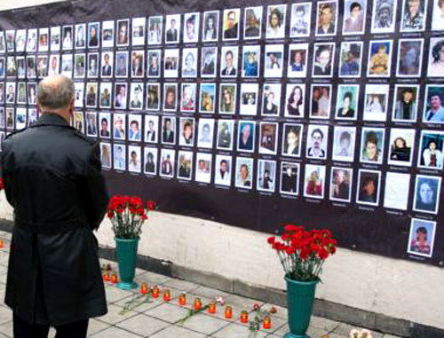 У плаката с фотографиями погибших заложников. Фото Yuri Timofeyev (RFE/RL)
