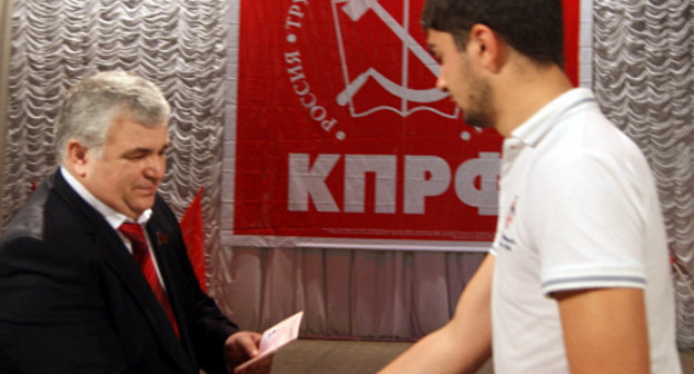 Первый секретарь Северо-Осетинского Рескома КПРФ Казбек Тайсаев вручает партийные и комсомольские билеты новым членам КПРФ и ЛКСМ во время торжетсвенного собрания в честь Дня Октябрьской революции. Владикавказ, 7 ноября 2012 г. Фото: Сайт Северо-Осетинского республиканского отделения КПРФ, http://www.rso-kprf.ru