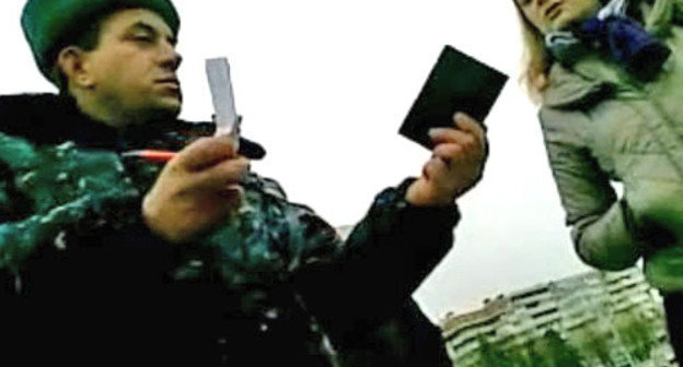 Сотрудник правоохранительных органов задерживает пикетчика и прохожих. Нальчик, 24 ноября 2012 г. Фото http://www.youtube.com