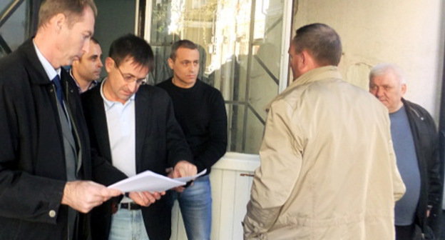 Охрана не пускает председателя ТОС "Кудепста" Игоря Васильева (справа) на встречу с депутатами и представителями администрации Сочи. Слева - советник председателя Городского собрания Сочи  Александр Старун со списком приглашенных. 30 ноября 2012 г. Фото Светланы Кравченко для "Кавказского узла"