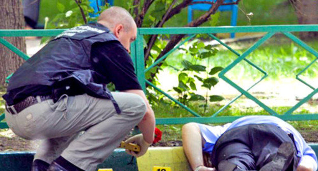 Сотрудник полиции проводят следственные действия на месте убийства Юрия Буданова. Москва, 10 июня 2011 г. Фото: Yuri Timofeyev (RFE/RL)