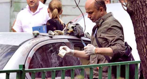 Оперативный сотрудник возле автомобиля Mitsubishi Lancer, который преступник облил и поджег. Москва, 10 июня 2011 г. Фото: Yuri Timofeyev (RFE/RL)