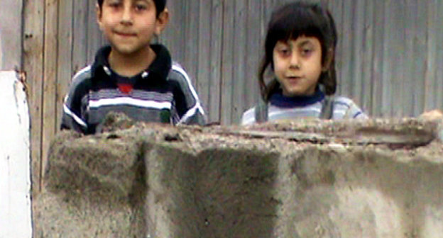 Внуки Филиппа Дарчиняна у времянки в немецком квартале, где проживает их семья. Армения, Спитак, 13 декабря 2012 г. Фото Армине Мартиросян для "Кавказского узла"