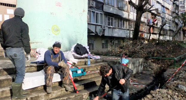 Рабочие выполняют работы возле дома 40 по улице Чебрикова, в котором произошло возгорание. Сочи, 16 декабря 2012 г. Фото Светланы Кравченко для "Кавказского узла"