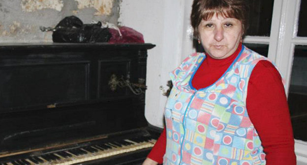 Жительница улицы Строительной, чей дом пострадал от наводнения, показывает на старинное немецкое пианино, на котором из-за повреждений больше нельзя играть. Дербент, 27 декабря 2012 г. Фото Патимат Махмудовой для "Кавказского узла"