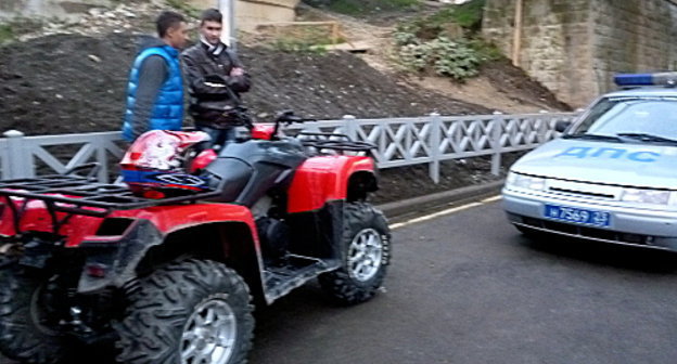 Молодые люди, катавшиеся по парковке торгового центра "Море Молл", и машина ДПС. Сочи, декабрь 2012 г. Фото Светланы Кравченко для "Кавказского узла"