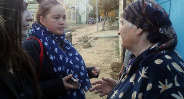 Руководитель дагестанского отделения волонтерской организации "Гражданский корпус" Луиза Дибирова и психолог из Москвы беседуют с жительницей Дербента, чей дом пострадал от наводнения. Октябрь 2012 г. Фото Нурлана Алиева