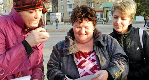 Участница митинга Ольга Алексеенко (слева) рассказывает прохожим политические перемены в стране под песни и частушки. Волгоград, 1 апреля 2013 г. Фото Татьяны Филимоновой для "Кавказского узла"