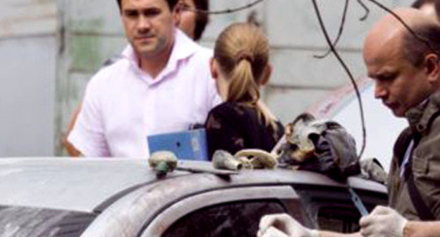 Работают криминалисты возле машины Mitsubishi Lancer, которая была сожжена. Москва, 10 июня 2011 г. Фото: Yuri Timofeyev (RFE/RL)