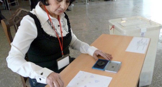 Член избирательной комиссии ставит печать в паспорт жителя Еревана, проголосовавшего на выборах в Совет старейшин. 5 мая 2013 г. Фото Армине Мартиросян для "Кавказского узла"