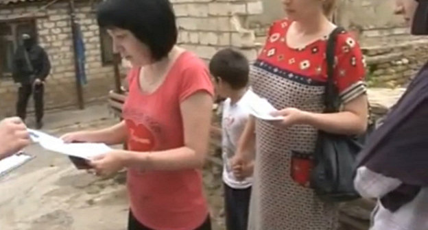 Вручение постановления об обыске в частном доме по улице Омарова в Махачкале, где проживает семья Сабины Шейхмурадовой. 11 июня 2013 г. Кадр оперативной видеосъемки НАК