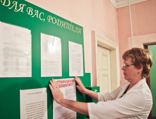 Работник одного из детских садов Волгограда размещает памятку об опасности заражения и мерах профилактики менингита на информационном стенде. 2013 г. Фото: http://volganet.ru