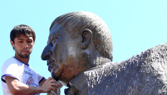 Блогер Нурлан Алиев во время акции по мытью памятника поэту Расулу Гамзатову. Махачкала, 7 июля 2013 г. Фото Патимат Махмудовой для "Кавказского узла"