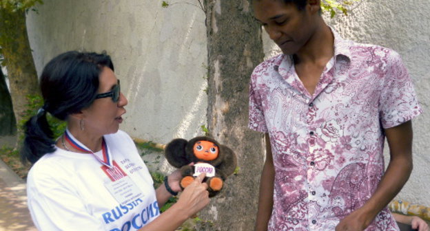 Участница акции с требованием писать название "Россия" на олимпийской форме русскими буквами объясняет прохожему цель мероприятия. Сочи, 3 сентября 2013 г. Фото Светланы Кравченко для "Кавказского узла"