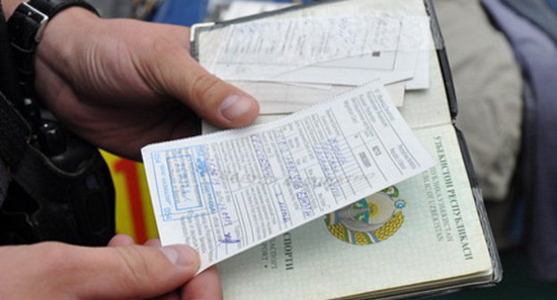 Сотрудник полиции проверяет документы у приезжего во время рейда по выявлению нелегальных мигрантов. Москва, август 2013 г. Фото пресс-службы ГУ МВД России по г. Москве, http://petrovka38.ru