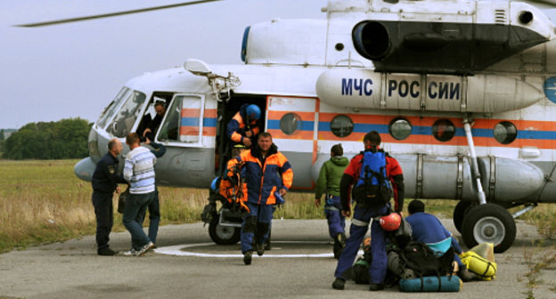 Cпасатели Карачаево-Черкесского поисково-спасательного отряда МЧС России у вертолета Северо-Кавказского регионального центра МЧС, на котором осуществлялась эвакуация тела туриста, погибшего в  Домбае. КЧР, 12 сентября 2013 г. Фото пресс-службы ГУ МЧС России по Карачаево-Черкесской Республике, www.09.mchs.gov.ru