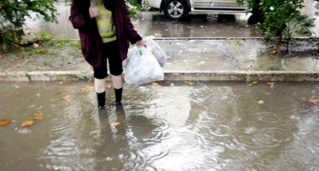 Сочи, 23 сентября 2013 г. Женщина пытается перейти от детского центра на улице Конституции к поликлинике. Фото Светланы Кравченко для "Кавказского узла"