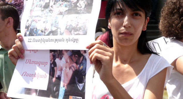 Мариам Саркисян, участница митинга против полицейского произвола, держит плакат с надписью "Лицо полицейского". Ереван, 27 августа 2013 г. Фото Армине Мартиросян для "Кавказского узла"