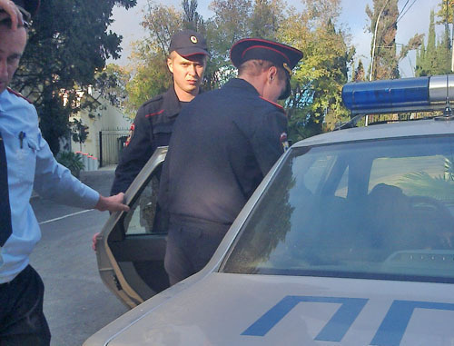 Полицейские усадили в машину Людию Лепсверидзе, которая была задержана во время проведения одиночного пикета. Сочи, 14 октября 2013 г. Фото Людмилы Лукьянкиной