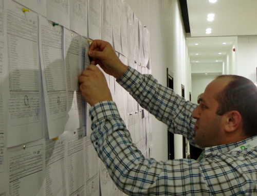 Работник ЦИК Грузии прикрепляет к стене копии итоговых
протоколов, полученных из избирательных участков. Тбилиси, 27 октября 2013 г. Фото Инны Кукуджановой для "Кавказского узла"