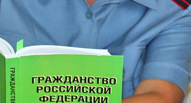 Сотрудник управления миграционной службы с информационно-справочным сборником Гражданство Российской Федерации. Фото: Управление федеральной миграционной службы по Астраханской области http://ufms-astrakhan.ru/