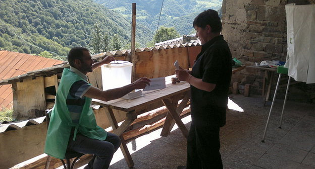 Голосование на местных выборах в Душетском муниципалитете Грузии. Избиратель готовится опустить бюллетень в урну для голосования. 15 июля 2014 г. Фото Григория Шведова для "Кавказского узла"