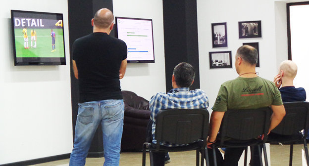 После закрытия избирательных участков и в ожидании первых
предварительных результатов голосования журналисты и сотрудники
Центральной избирательной комиссии смотрят чемпионат мира по футболу. Фото Инны Кукуджановой для "Кавказского узла"