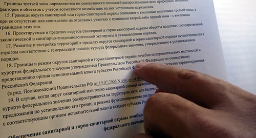 Олег Вронский показывает закон где написано, что охранных зон курорта в Сочи больше нет. Фото Светланы Кравченко для "Кавказского узла"