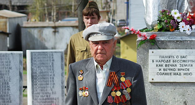 Ветеран Великой Отечественной войны 1941-1945гг., возле Вечного Огня. Фото: Логиновский Денис, https://ru.wikipedia.org/wiki/%C2%E5%F2%E5%F0%E0%ED%FB_%C2%E5%EB%E8%EA%EE%E9_%CE%F2%E5%F7%E5%F1%F2%E2%E5%ED%ED%EE%E9_%E2%EE%E9%ED%FB