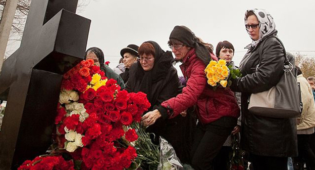 Возложение цветов к поклонному кресту в память о погибших на месте трагедии. Фото: https://upload.wikimedia.org/wikipedia/commons/thumb/0/0d/Krest_poklonnyi_terakt.JPG/640px-Krest_poklonnyi_terakt.JPG