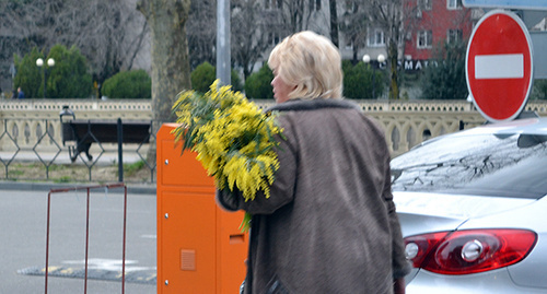 Женщина с букетом мимозы. Фото Светланы Кравченко для "Кавказского узла"