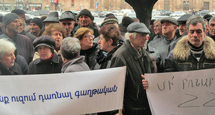 Акция бывших сотрудников завода "Наирит". Надписи на транспарантах: «Мы не хотим стать эмигрантами» (слева), «Не терзайте законы Республики Армении!» (справа). Ереван, 5 марта 2015 г. Фото Тиграна Петросяна для "Кавказского узла"
