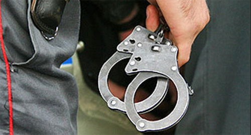 Наручники в руках сотрудника полиции. Фото: http://www.riakchr.ru/wp-content/uploads/2014/12/photo_77964.jpg