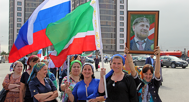 Портрет Рамзана Кадырова держит участница митинга в честь празднования Дня Республики в Чечне. Сентябрь 2014 г. Фото Магомеда Магомедова для "Кавказского узла"