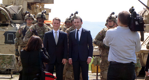 премьер-министр Грузии и заместитель Чрезвычайного и Полномочного Посла США в Грузии фотографируются на фоне участников военных учений.Фото Инны Кукуджановой