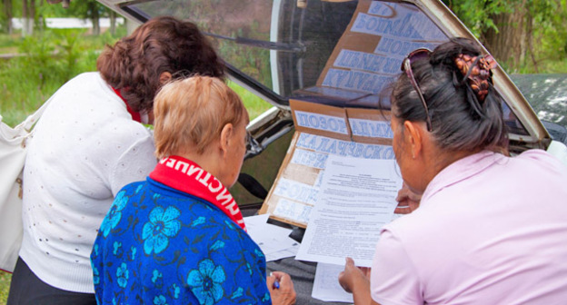 Участники пикета в поселке Береславка Калачевского района Волгоградской области потребовали заменить окна в детсаду. На снимке: жители поселка подписывают петицию. Волгоград, 30 мая 2015 г. Фото Татьяны Филимоновой для "Кавказского узла"