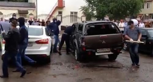 Погромщики разбивают кувалдой автомобиль СМГ. Грозный, 3 мая 2015 г.