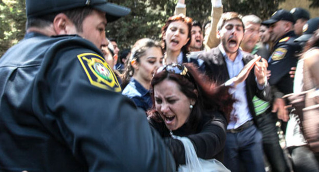 Полицейский задерживает протестующих против вынесения судом обвинительного приговора активистам движения Nida. Баку, 6 мая 2014 г. Фото Азиза Каримова для "Кавказского узла"