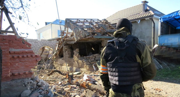 Сотрудник силовых структур на фоне жилого дома, разрушенного в результате спецоперации. Село Чегем-Второй, КБР, ноябрь 2014 г. Фото http://nac.gov.ru/