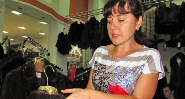 Представитель предпринимательницы Наталья Клочкова в торговом центре показывает поврежденный мех на шубах. Астрахань, 19 июля 2015 г. Фото Вячеслава Ященко для "Кавказского узла"