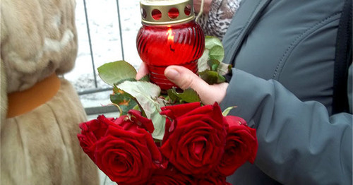 Участник панихиды по Немцову держит цветы и свечу. Москва, 3 марта 2015 г. Фото Карины Гаджиевой для "Кавказского узла"