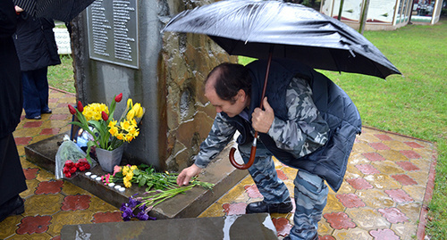 Мужчина возлагает цветы у фотографии Немцова. Сочи, 1 марта 2015 г. Фото Светланы Кравченко для "Кавказского узла"