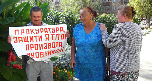 Участник одиночного пикета держит плакат в поддержку сотрудников ахтубинского АТП. Ахтубинск, 21 сентября 2015 г. Фото Елены Гребенюк для "Кавказского узла"