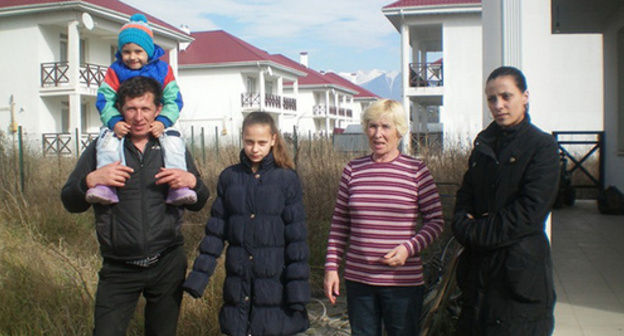 Семья Савельевых перед пустующими домами в поселке для переселенцев. Фото Алексея Савельева