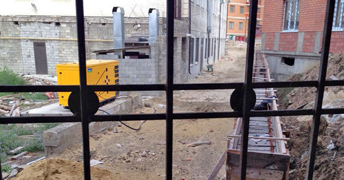 Вид из окна первого этажа дома по улице Булача 23 в Махачкале. Банкетный зал "Шах" (задняя его сторона) и строительство забора. 22 октября 2015 г. Фото: Татьяна Гарунова