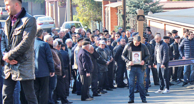 Участник траурной процессии с портретом Владимира Цкаева. Фото Эммы Марзоевой для "Кавказского узла"