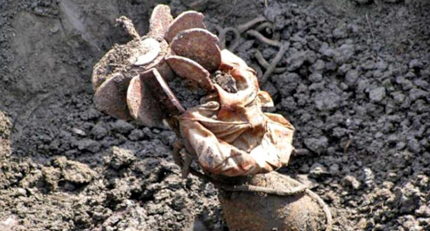 Неразорвавшийся снаряд в земле. Фото http://www.mchs.gov.ru/dop/archive/photo/Gumanitarnie_operacii_MCHS/Gumanitarnoe_razminirovanie_v_CHechensko