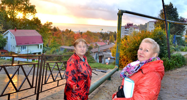 Нина Борисенко (справа) и еще одна дольщица показывают место, где должны были быть построены гаражи. Сочи, 22 ноября 2015 г. Фото Светланы Кравченко для "Кавказского узла"