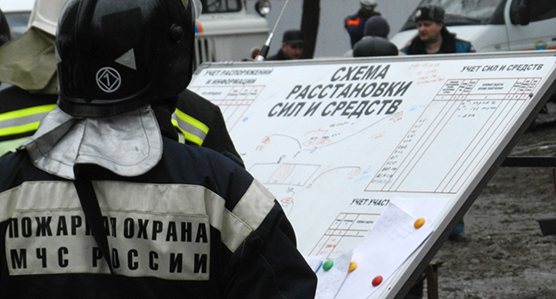 Сотрудник МЧС около Плана расстановки сил и средств при ликвидации пследствий взрыва. Фото Татьяны Филимоновой для "Кавказского узла"