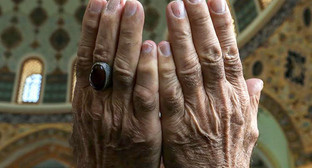 Руки верующего в молитвенном жесте. Фото Азиза Каримова для "Кавказского узла"